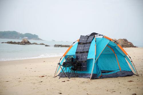 Tente, panneau solaire et Power station NPS exposs sur une plage